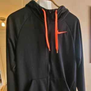 Hoodie - Fint använt skick. Svart med orange märke och snörning. 