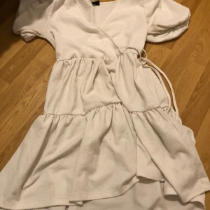Klänning - En vit klänning från Gina Tricot, den är jätteskön och har ”puff ärmar”. Jättefint till midsommaren eller skolavslutningen. Den har en urringning 