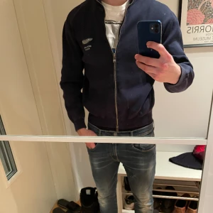 Aston Martin zip från hackett - Skitsnygg tröja från hackett med aston martin loggan. Perfekt med skjorta under! Skick 8,5/10 storlek S Nypris 1800 Mitt pris 500!