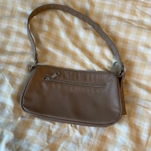Axel väska Bikbok - Den är en jätte fin och vacker väska. Den är perfekt till alla kläder och jag har haft den några gånger. Och den är typ brun besh. 