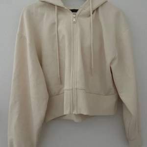 Skön zip hoodie från Zara i en fin krämvit färg. Lite kortare i längden. Använd en gång