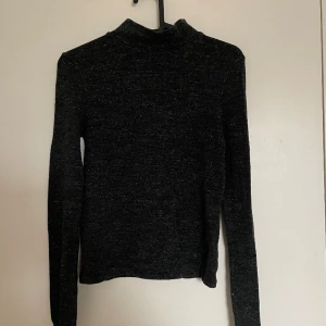 Mörkgrå polotröja - Mörkgrå spräcklig polotröja med tight passform. Köparen står för eventuell frakt