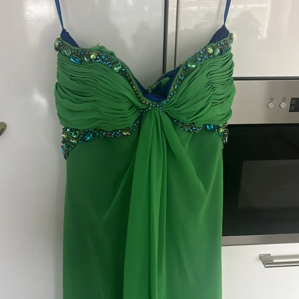 En fin grön klänning med diamanter som kan användas vid bal, event, galor m.m. Man kan bära den ärmlös eller med band som de på den sista bilden. Endast använd en gång, köpt för 1200kr men säljer för 600 då det var längesen den köptes. Klänningar.