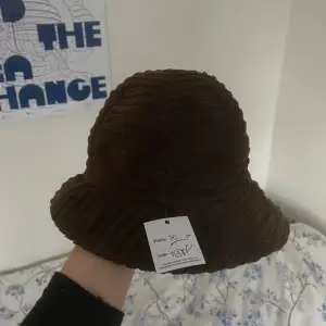 Brun hatt i manchestertyg ish, väldigt liten i storleken, köpt på humana och aldrig använd så säljer vidare den med samma pris (som syns i första bilden på prislappen som sitter kvar)✨Verkar ursprungligen vara något italienskt märke