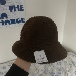 Brun manchesterhatt - Brun hatt i manchestertyg ish, väldigt liten i storleken, köpt på humana och aldrig använd så säljer vidare den med samma pris (som syns i första bilden på prislappen som sitter kvar)✨Verkar ursprungligen vara något italienskt märke