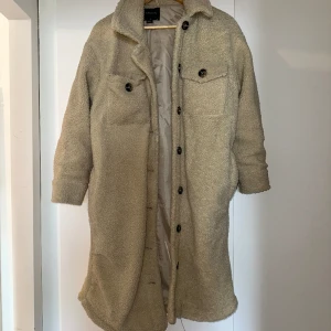 Lång kappa  - Mycket fint skick, ena jackfickan är trasig på insidan men det går säkert att sy ihop enkelt.