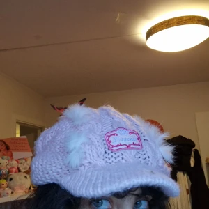 Rosa fluffig stickad keps med prinsessa brodering - Väldigt fint skick, skulle säga att det är no size då den töjs ut :) Tror att den är handgjord men osäker.