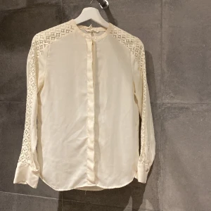 Beige blus med spets - Beige blus med spetsärmar.  Sparsamt använd. Hittar inget att anmärka på. 