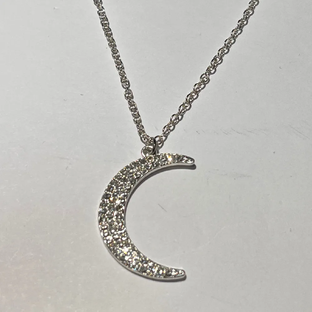 ett silver halsband med en måne ☾ det är väldigt ljust och är mer som en blandning av guld och silver. aldrig använd, i fint skick! frakt 18kr med swish, eller använd köp nu!. Accessoarer.