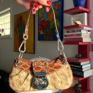 Äkta guess miniväska - Säljer denna supersöta miniväska från guess! Är lite skrapad på metallbiten framtill (skriv om du vill ha bild🥰syns även lite på fösta bilden) men annars i princip i nyskick!💓💓