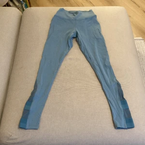 Gymshark tights - Blå tights från gymshark med Leah längst beror benen. Gummibandet på baksidan av byxorna har fläkts upp på ett ställe vilket syns på tredje bilden. Därav priset