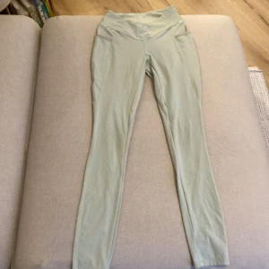 Gymshark tights  - Gröna tights från gymshark i en ljus sage. De har fickor och en lätt v-Shape framtill.
