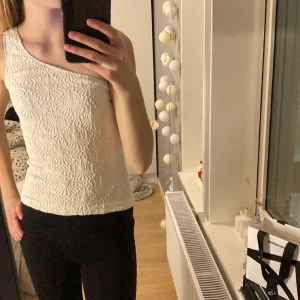 Oneshoulder topp - En superfin one-shoulder topp med fint mönster. Använd ca 1 gång och inga defekter.