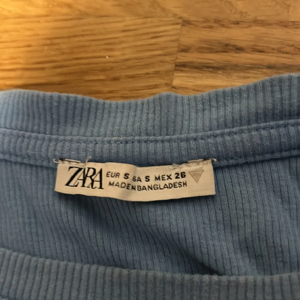 En blå tröja från zara med volanger. Kommer inte till användning och säljer därför. Storlek S men passar även M då den är strechig.. Toppar.