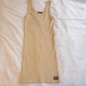 Åtsittande klänning - Säljer en klänning i nyskick från DrDenim. Den är i storlek S men passar även mig perfekt som brukar vara storlek M. Den har aldrig använts då den inte riktigt är min stil :)