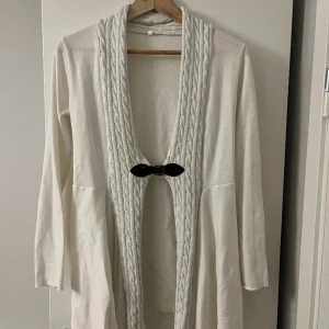 Ribbstickad kofta - Litet spänne i högre midjenivå. Sparsamt använd 