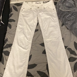 Miss me jeans - Super coola low waist Miss me jeans köpta här på plick med detaljer på fickorna. Byxorna är straight fit  och den ända defekten är ett ihopsytt hål mellan benen på byxorna som sytts av en tidigare säljare. Midjemått: 38cm, innerbenslängd: 75cm.
