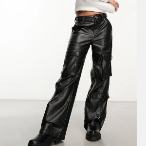 Lågmidjade cargo skinnbyxor - Säljer ett par lågmidjade cargo skinnbyxor, första bilden är hur dem sitter på men modellen på andra bilden, jättesköna och mjuka på insidan, är i storlek 32 men passar lika bra på storlek 34, använd bara två gånger så nyskick, låter inte alls mycket