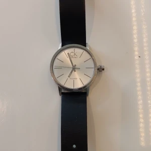 Fin CK klocka med marinblå armband. - Calvin Klein klocka med blått armband. I nyskick och fungerande med ett nästan nytt batteri. Nypris 2098:-