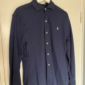 Polo Ralph Lauren Skjorta - Säljer min Polo Ralph Lauren skjorta. Den är marinblå och i storlek M. Passar dig som är ca 176-183. Funkar för tjejer också