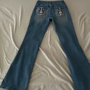 Blå jeans med broderade/mönstrade fickor. I storlek xs-s, säljer då de är lite för korta på mig som är 170cm. I bra skick förutom två små hål (se bild 3&4)