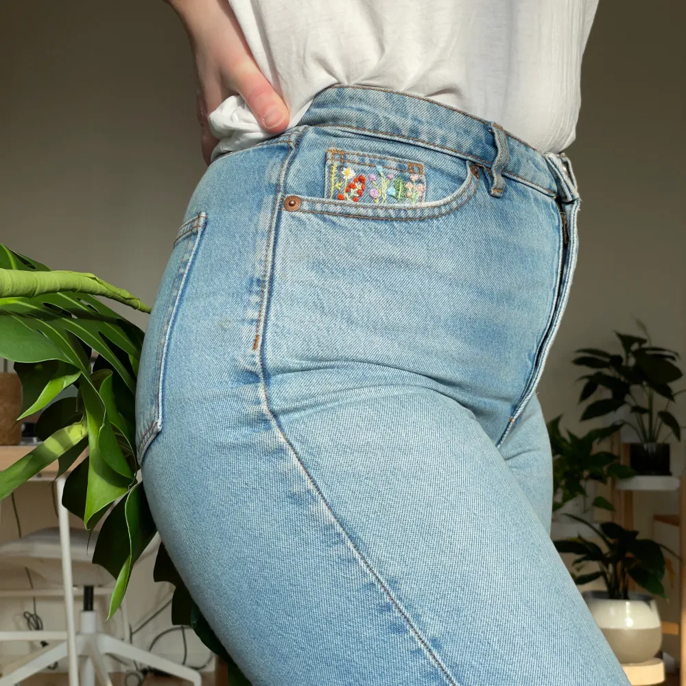 Ljusblå jeans från Monki som jag har broderat på. Högra fickan har en liten blomsteräng och på vänster höft/ljumske finns ett litet bi. Storlek 27, passar en S/XS beroende på hur man vill att passformen ska vara.. Jeans & Byxor.