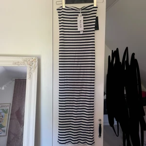 Randig klänning - Randig tubtopp klänning från Na-KD. Köpt förra sommaren men aldrig kommit till användning då jag inte är största fanet av tubtoppar på mig. Annars älskar jag den!  Ränderna är blåa och vita 🥰🫐🥥  slits baktill.