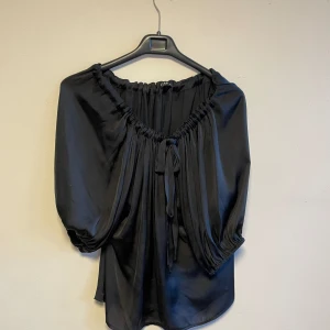 Blus  - Svart kortärmad blus med knyte i ”halsen”