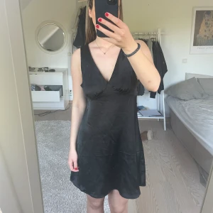 Svart satinklänning  - Jättesöt svart satinklänning från bikbok. Använd en gång. Stl M