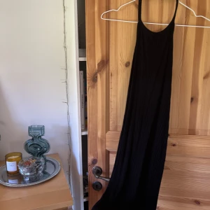 Klänning - Svart ribbad bodyconklänning med halterneck. Tunn och superskön! Sitter tight och är otroligt stretchig. Låg rygg!   viskos & elastan
