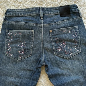 Söta jeans rosa rhinestones - Säljer mina jättefina jeans med detaljerade fickor då de är alldeles för små på mig. Hör gärna av dig vid frågor eller för mer bilder💗Pris kan diskuteras! Mått:  Midja rakt över - 37cm Innerbenslängd - 81cm Total längd - 103cm