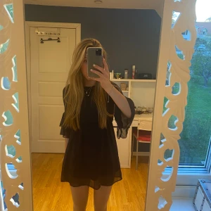 Kort marinblå klänning, H&M - Jättefin kort klänning från H&Ms barnavdelning i storlek 146, den är marinblå och ärmarna är trekvarts med volang sista biten.