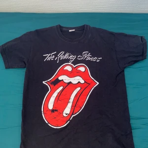 Vintage The  Rolling Stones T-Shirt - En Vintage The Rolling Stones T-shirt från Fruit Of The Loom, Storlek Large men sitter som en Medium/Baggy small  Riktigt fräsch sommar T-shirt som passar med allting. 