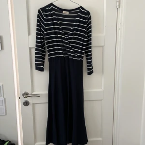 Klänning Jumperfabriken - Fin klänning från Jumperfabriken i storlek S men passar snarare som en M. Rätt lång. I gott skick. Mörkblå och vita ränder på överdelen
