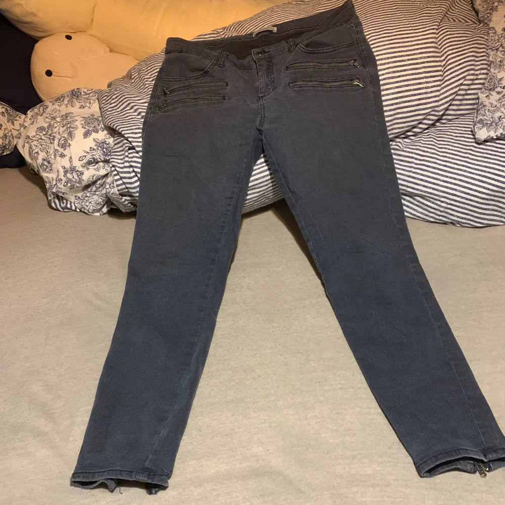 Grå/svarta jeans med dragkedja vid fötterna . Jeans & Byxor.