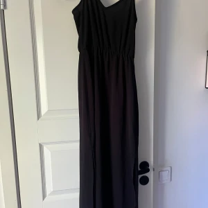 Svart klänning hm  - Säljer denna svarta långklänningen från hm. Storlek 32, i svart. Använd enstaka gång.