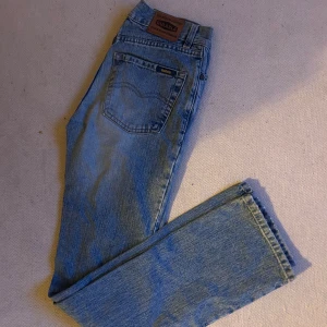 Gul och blå  jeans mid waist  - Säljer mina gul och blå jeans i nyskick. De sitter under naveln på mig och är i en jättefin ljus färg. De är typ en blandning av brootcut och straight jeans.