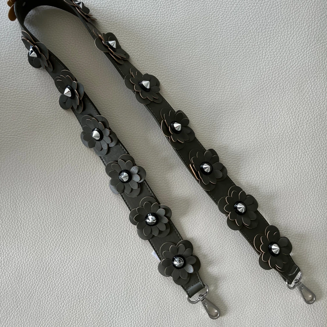 Grönt väskband med blomdetaljer 