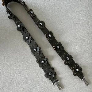 Grönt väskband med blomdetaljer  - Grönt väskband med gröna blommor o silver taggar