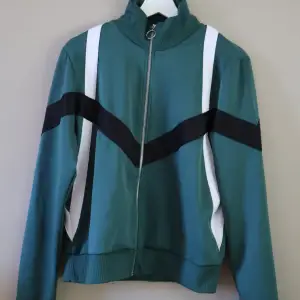 Grön tränings zip up med vita och svarta ränder. Knappt använd från Gina tricot. Storlek M. 