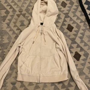 Juicy couture kofta - Beige kofta, en fläck och en av mettal plupparna har ramlat av(bild 3 och 4) lite anurlunda material en de ”vanliga” men köpte ändå för 1200