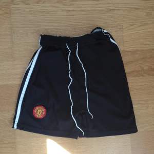 Svarta Manchester United shorts för barn och använd få gånger och för ett bra pris