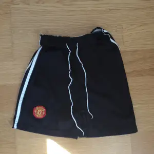 Svarta Manchester United shorts för barn och använd få gånger och för ett bra pris