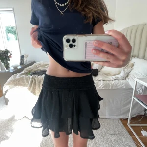 Svart volangkjol - Sjukt snygg volangkjol!! Aldrig använd därav att den säljs. Vikt ner kanten då ja tycker de är snyggare så. Resårband så passar många storlekar!