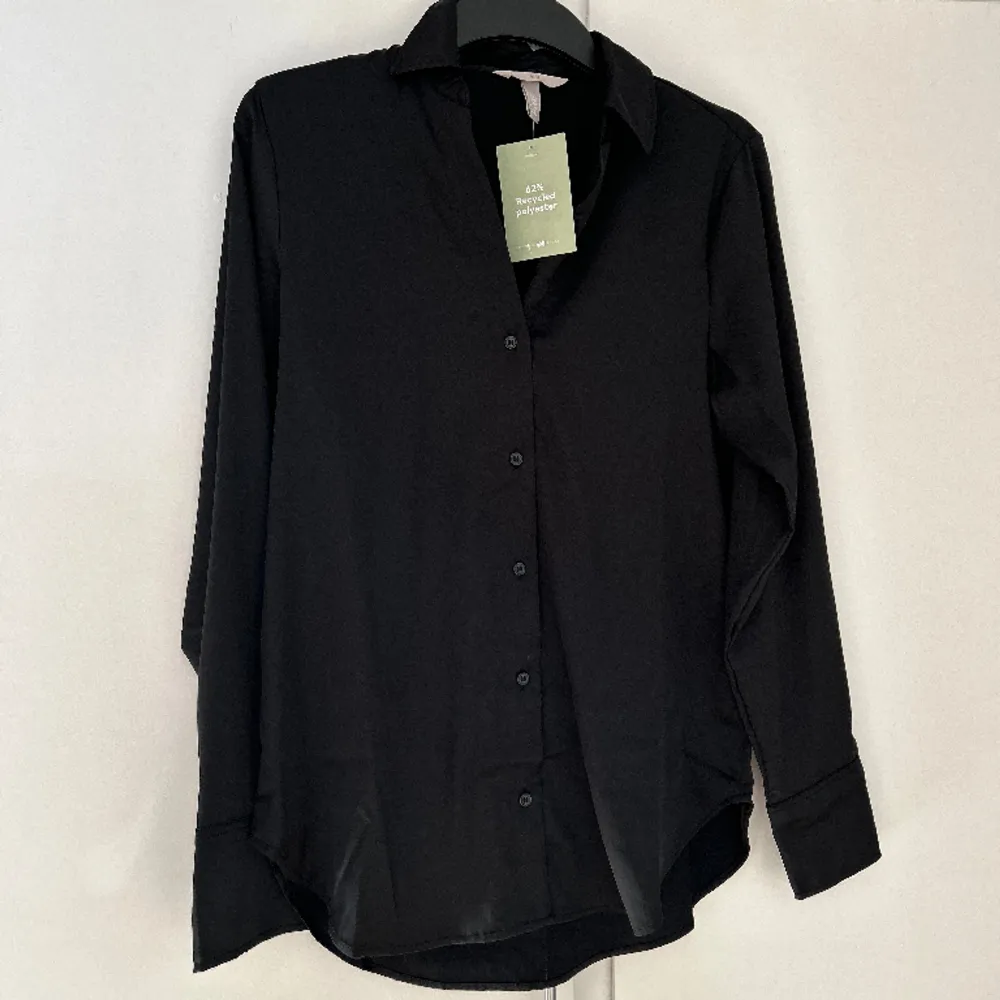 Säljer denna svarta blus från H&M. Storlek XS. Blusen är aldrig använd och säljs just pga detta. Frakt tillkommer för köparen! Ingen ångerrätt! . Blusar.