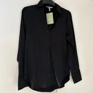 Säljer denna svarta blus från H&M. Storlek XS. Blusen är aldrig använd och säljs just pga detta. Frakt tillkommer för köparen! Ingen ångerrätt! 