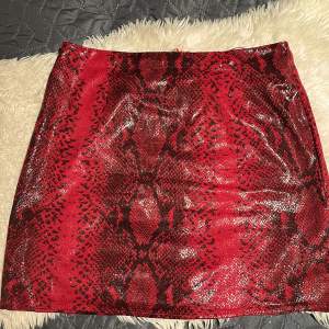 Rödglittrig kjol med ormmönster Storlek: 38 Missguided  Säljes för 70kr+fraktpris