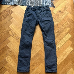 Mörkblå chinos från Nudie Jeans. Stkl: 27 i midjan och 30 i längd - Måttligt använda