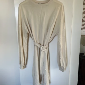 Klänning  - Väldigt skön och go klänning från Nelly.  Färgen är vit/beige. Det går fint att ha utan bandet med. Väldigt sparsamt använd.🩷