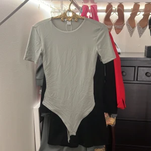 Body, perfekt under jeans - Grönaktig, otroligt mjuk. Knappar nertill. Använd en gång. Stretchig. Får superfin figur i den. 